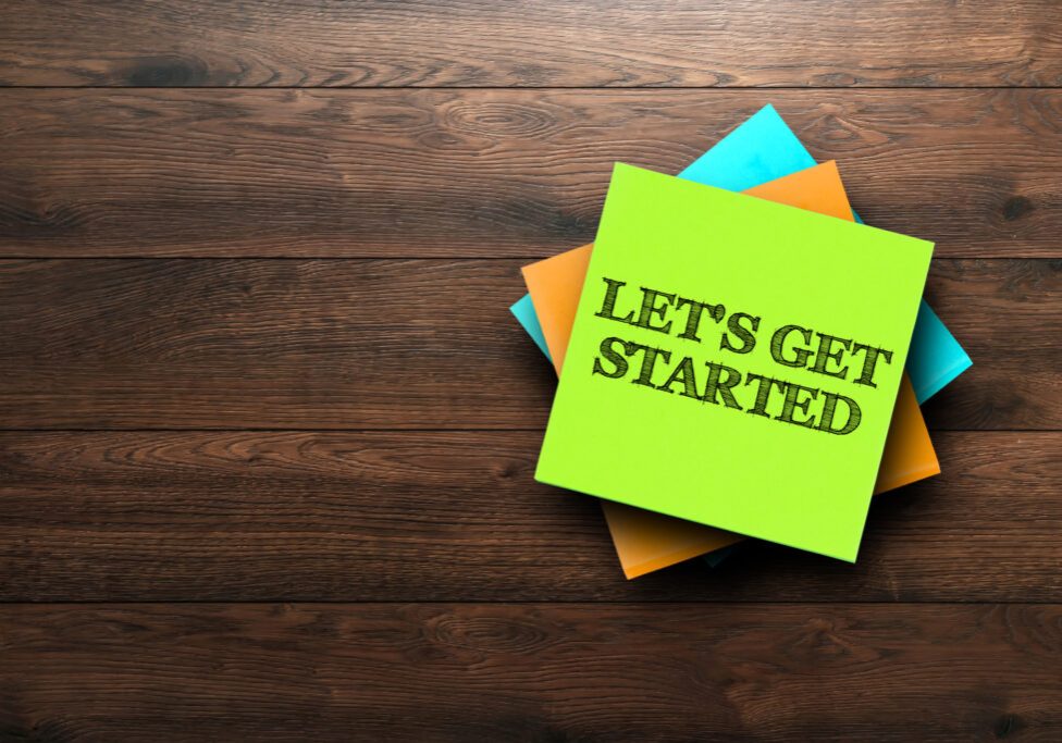 Let's Get Started, the phrase is written on multi-colored stickers, on a brown wooden background. Business concept, strategy, plan, planning.